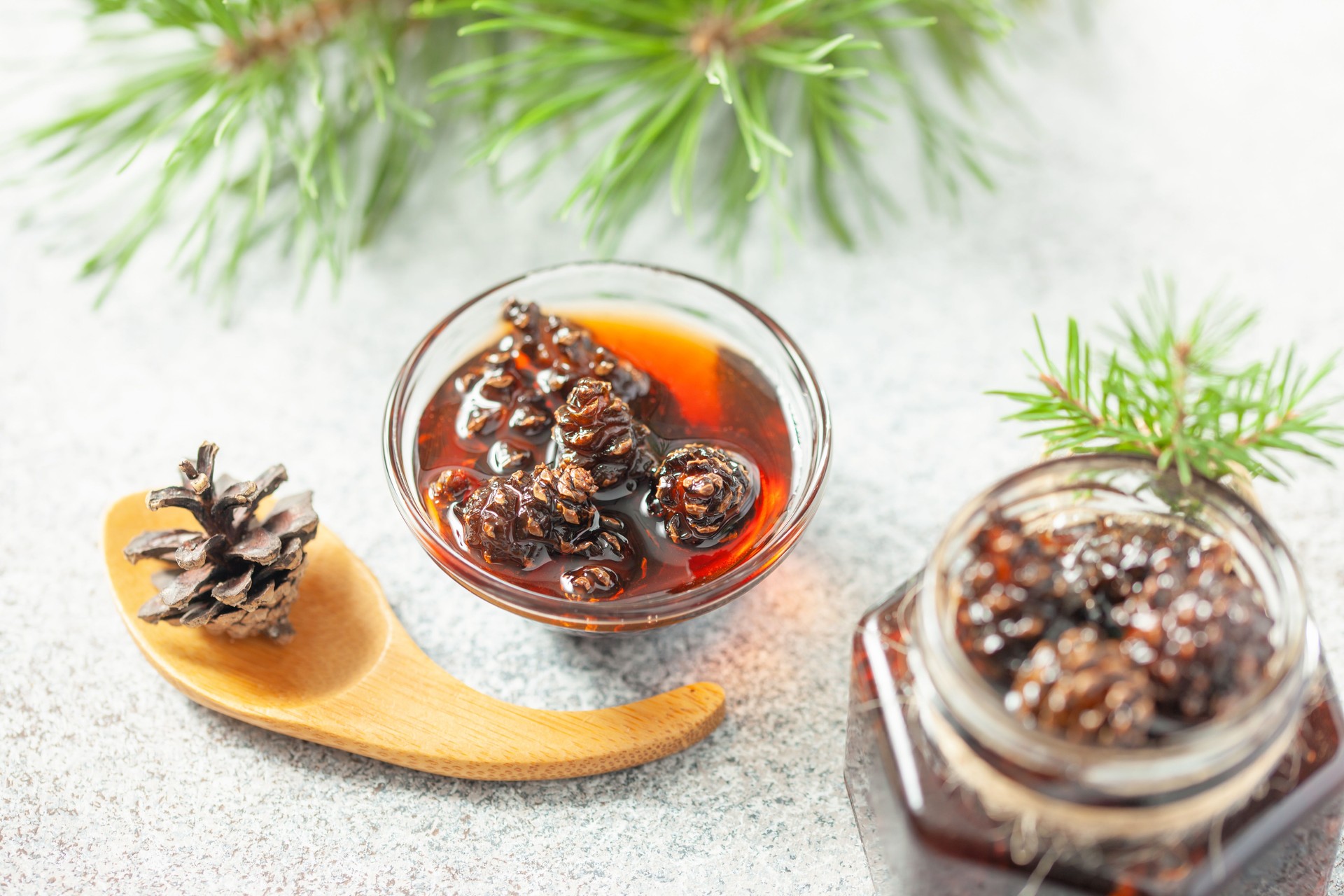 Young mini pine cones jam in jar. Healthy and tasty dessert